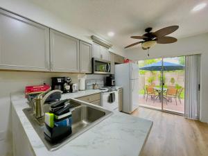 a kitchen with a sink and a refrigerator at Fort Myers Beach Escape 3 Miles Away Sleep 7 in Fort Myers Beach