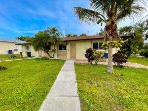a house with a palm tree and a sidewalk at Fort Myers Beach Escape 3 Miles Away Sleep 7 in Fort Myers Beach