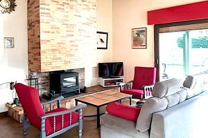 a living room with red chairs and a fireplace at Maison charmante à Vielle-Saint-Girons avec vue sur le lac. in Vielle-Saint-Girons