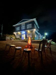 a fire pit in front of a house at night at The Black Magic Cottage in Ooty