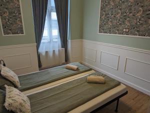 two beds in a room with a window at Classic Deluxe Tapolca in Tapolca