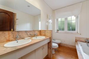 Un baño con dos lavabos y un inodoro. en La Casa De Rita, en Baiona 8 fotos más