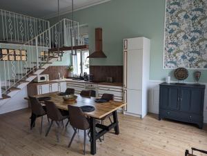 a kitchen with a table and chairs and a refrigerator at Classic Deluxe Tapolca in Tapolca