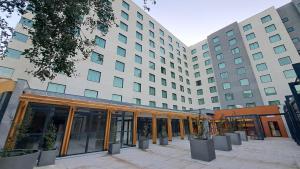 an office building with a courtyard in front of it at Hotel Diego de Almagro Pudahuel Aeropuerto in Santiago