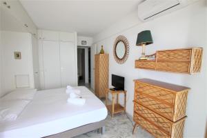 a bedroom with a bed and a desk and a tv at AMAZING SEA VIEW APARTMENT in Cannes