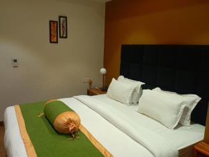 1 dormitorio con 1 cama grande con almohadas blancas en HOTEL SHOOLIN GRAND en Guwahati