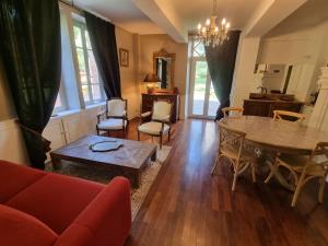 uma sala de estar com um sofá vermelho e uma mesa e cadeiras em Le Manoir du Thouron em Saint-Sulpice