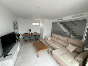 a living room with a couch and a table at Duplex penthouse close to the beach in Costa Ballena
