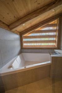 una grande vasca da bagno in una stanza con finestra di Savoielac - La Clusaz- Piscine intérieure : Chalet Viking a La Clusaz Altre 20 foto