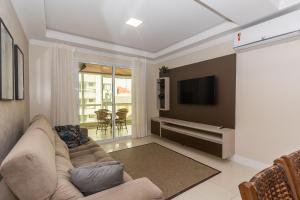 een woonkamer met een bank en een tv bij 006 - Amplo 3 quartos com vista mar em Bombas in Bombinhas