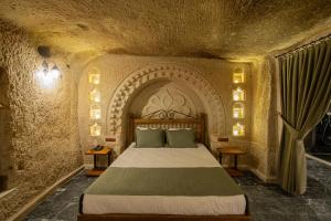 Un dormitorio con una cama en una habitación de piedra. en Ares Cave Suites, en Göreme