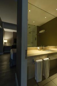 baño con lavabo y espejo grande en Hotel Terrado Rancagua en Rancagua