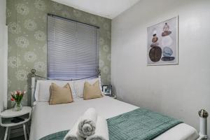 a small bedroom with a bed and a window at Livestay-Two Bedroom Apartment in Clapham in London