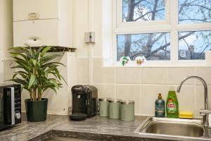 a kitchen counter with a sink and a window at Livestay-Two Bedroom Apartment in Clapham in London