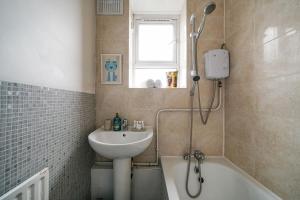 a bathroom with a sink and a bath tub and a shower at Livestay-Two Bedroom Apartment in Clapham in London