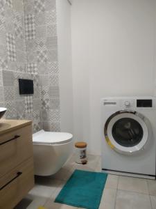 a bathroom with a washing machine and a toilet at Apartament Białystok in Białystok