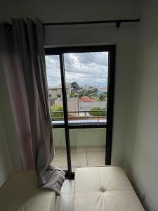 een kamer met een raam met een bed en uitzicht bij Apartamento 1 quarto com garagem in Ponta Grossa