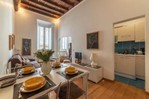 a kitchen and living room with a table and chairs at Con il Pantheon fuori dalla finestra - FromHometoRome in Rome