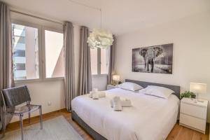 - une chambre avec un grand lit blanc et une fenêtre dans l'établissement Superb spacious and tastefully renovated accommodation, à Saint-Laurent-du-Var