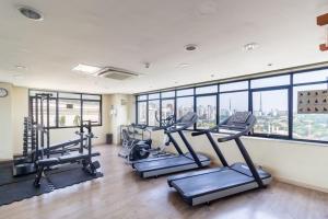 a gym with treadmills and ellipticals in a room with windows at Flat Hotel Transamérica - Limpeza diária e garagem in São Paulo