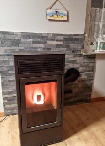 a brick fireplace with a fire in it at Haus Ankerliebe in Dornum