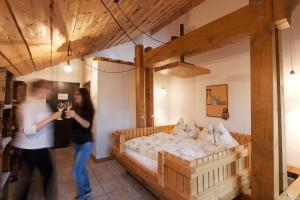 a woman taking a picture of a bed in a room at Hotel Arkanum in Salgesch