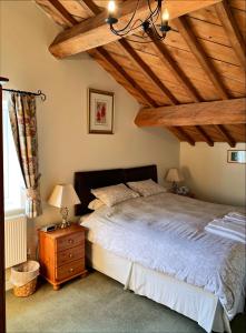 1 dormitorio con cama y techo de madera en The Farm Burscough, en Burscough