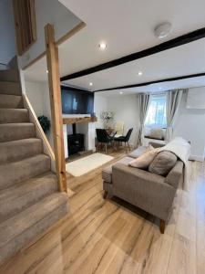 ein Wohnzimmer mit einem Sofa und einer Treppe in der Unterkunft Millstone Cottage Newmillerdam in Hill Top