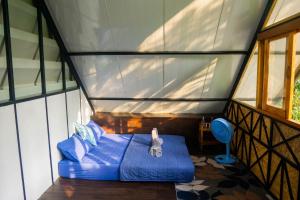 een kamer met een blauw bed in een huis bij Oasis forest garden in Ban Takuk Nua