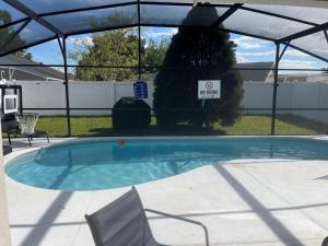 una gran piscina con pérgola y un cartel en Disney Themed House Free Heated Pool close Disney 5br 9bd, en Orlando