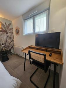 a bedroom with a desk with a tv and a window at Maison Brizon collection Pepeaz in Tours