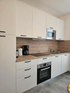 a kitchen with white cabinets and a microwave at Maison Brizon collection Pepeaz in Tours