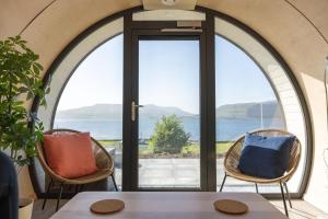 a dining room with a view of the ocean at Loch Buie Pod in Pennyghael