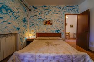 1 dormitorio con 1 cama grande y pared azul en Agriturismo Il Poderino en Grosseto