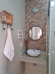 a bathroom with a sink and a mirror at Pousada Vila Flor in Rio das Flores