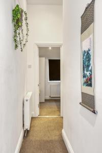 a hallway with a mirror on a wall at Vibrant 2-Bed by Bow in London