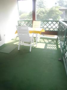 - deux chaises blanches et une table sur une terrasse couverte dans l'établissement Maison de 3 chambres avec jardin clos et wifi a Vielle Saint Girons, à Vielle-Saint-Girons