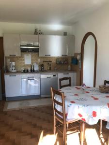 a kitchen with a table and a kitchen with white cabinets at Le petit gîte in Saint-Étienne-le-Laus +16 photos
