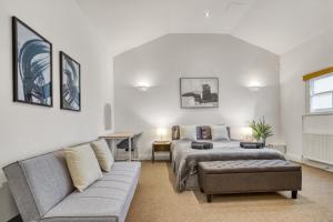 a living room with a bed and a couch at Vibrant 2-Bed by Bow in London
