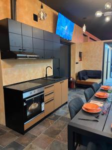 uma cozinha com um fogão e uma sala de jantar com uma mesa em Diamond Hostel em Divčibare