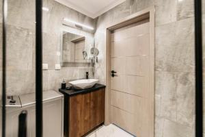 ein Bad mit einem Waschbecken, einem WC und einer Tür in der Unterkunft Apartament B Park City in Ostrowo