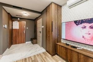 ein Wohnzimmer mit einem großen Bildschirm in einem Zimmer in der Unterkunft Apartament B Park City in Ostrowo
