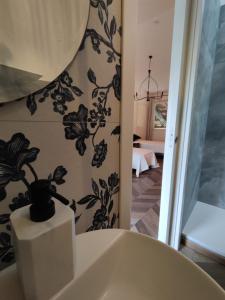 a bathroom with a white tub with a plant on the wall at Garda Relais Antica Romelia in Montichiari