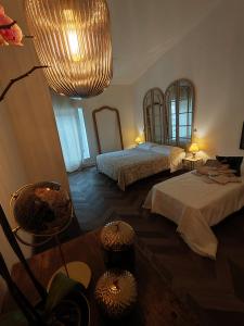 a bedroom with two beds and a large chandelier at Garda Relais Antica Romelia in Montichiari