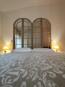 1 Schlafzimmer mit 2 Betten und 2 Lampen an der Wand in der Unterkunft Garda Relais Antica Romelia in Montichiari