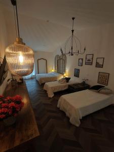 a large room with two beds and a chandelier at Garda Relais Antica Romelia in Montichiari