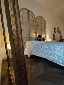- une chambre avec un lit et un miroir dans l'établissement Garda Relais Antica Romelia, à Montichiari