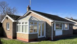 a house with a conservatory on the side of it at Dawson's Corner Retreat in Beadnell