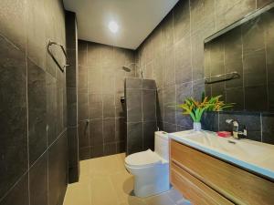 e bagno con servizi igienici, lavandino e doccia. di Spacious Private Villa Modern Style near beach a Thai Muang