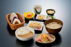 stół z miskami i talerzami jedzenia w obiekcie HOTEL GATE 88 w mieście Naruto
